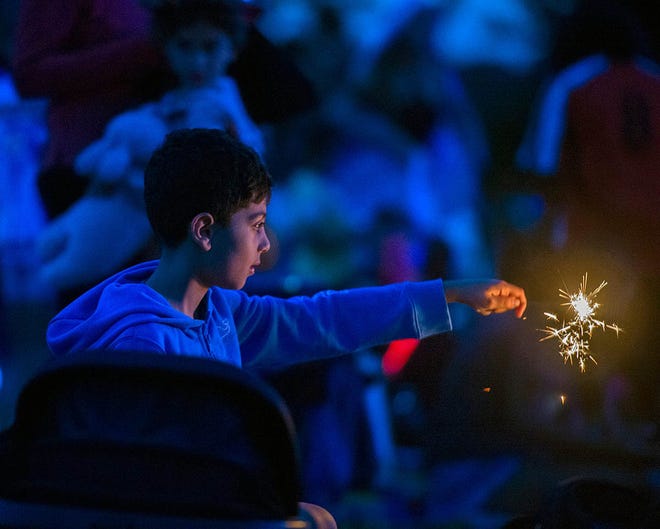 A youngster with a sparkler at the Stars and Stripes Over Framingham event to celebrate the Fourth of July at Farm Pond Park, Ma. on June 28, 2024.