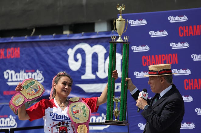 Miki Sudo celebrates with the trophy after winning the women's title during the 2024 Nathan's Famous Fourth of July hot dog eating competition at Coney Island in the Brooklyn borough of New York on July 4, 2024. Sudo won after consuming a record-breaking 51 hotdogs.