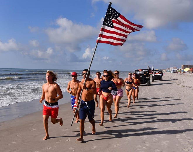 An annual 4th of July tradition, Brevard County (Fla.) Ocean Rescue Lifeguards run the American flag down the beach for the 4th of July. On Thursday morning a group ran the flag from Cherie Down Park in Cape Canaveral to the jetties at Jetty park and back before their shift started for the holiday. Other lifeguards in other locations did the same.