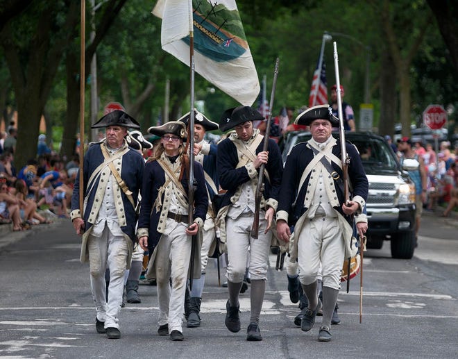 Revolutionary War reenactors walk in formation in the the Alcott Park July 4th Parade in Milwaukee on Thursday, July 4, 2024.