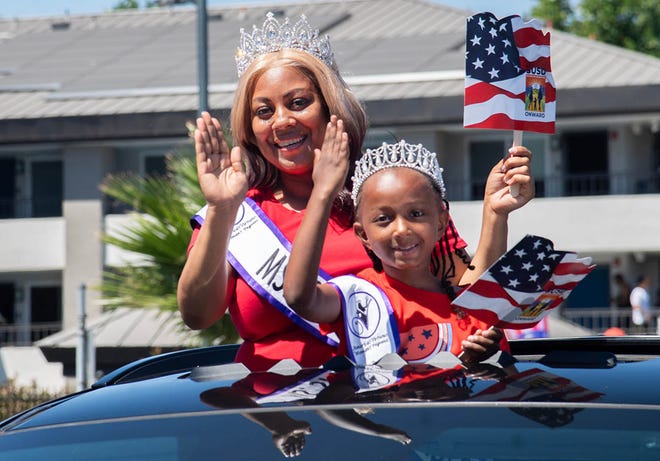 Nisha Gusters, left, and Denise King, Miss Stockton and Little Miss Stockton from America’s Virtuous Women’s Pageant ride in a vehicle in the United Veterans Council of San Joaquin’s annual 4th of July parade in downtown Stockton, Calif. on Jul. 4. 2024.