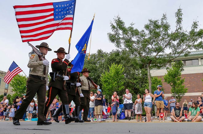 The Sheboygan County Sheriff color guard presents the colors during the Fourth of July parade, Thursday, July 4, 2024, in Sheboygan, Wis.