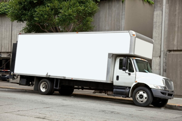 White moving van parked on an urban street