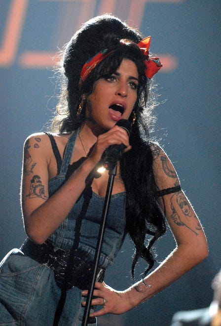 "We can do it!" Amy Winehouse channels the iconic Rosie the Riveter with her denim look and red bandana at the 2013 MTV Europe Music Awards.