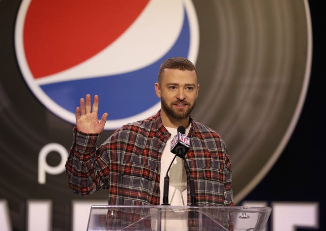 Justin Timberlake subtly showed his patriotism in a red and blue flannel paired with a plain white shirt as he waved hello to the media during a press conference for the Super Bowl LII halftime show.