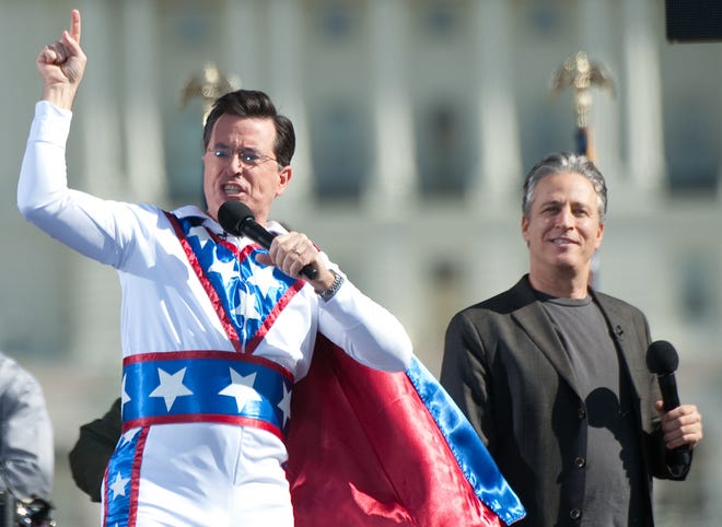 Stephen Colbert (left, with Jon Stewart) sports an American flag-themed superhero costume while performing on the National Mall in 2010.